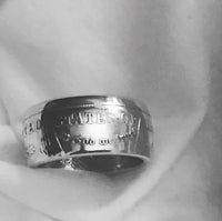 a silver ring with a coin on it